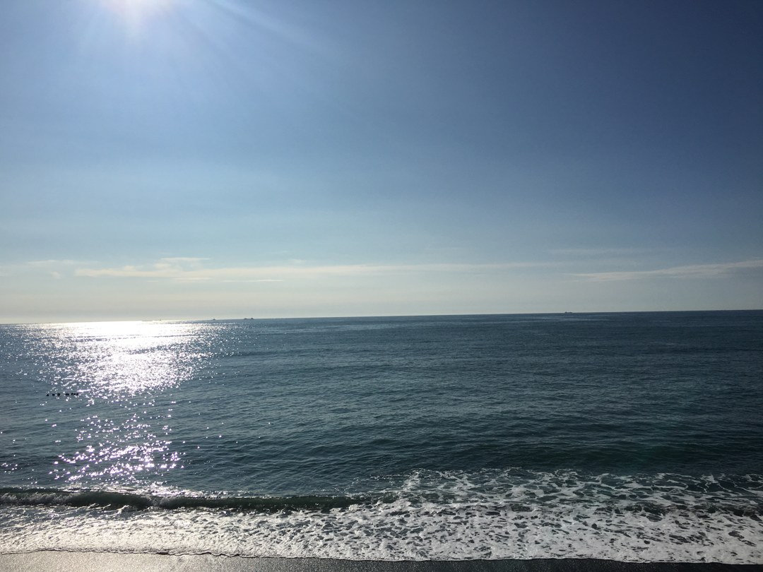 朝の広の浜。海の上に光の道が一本、波打ち際まで届いている