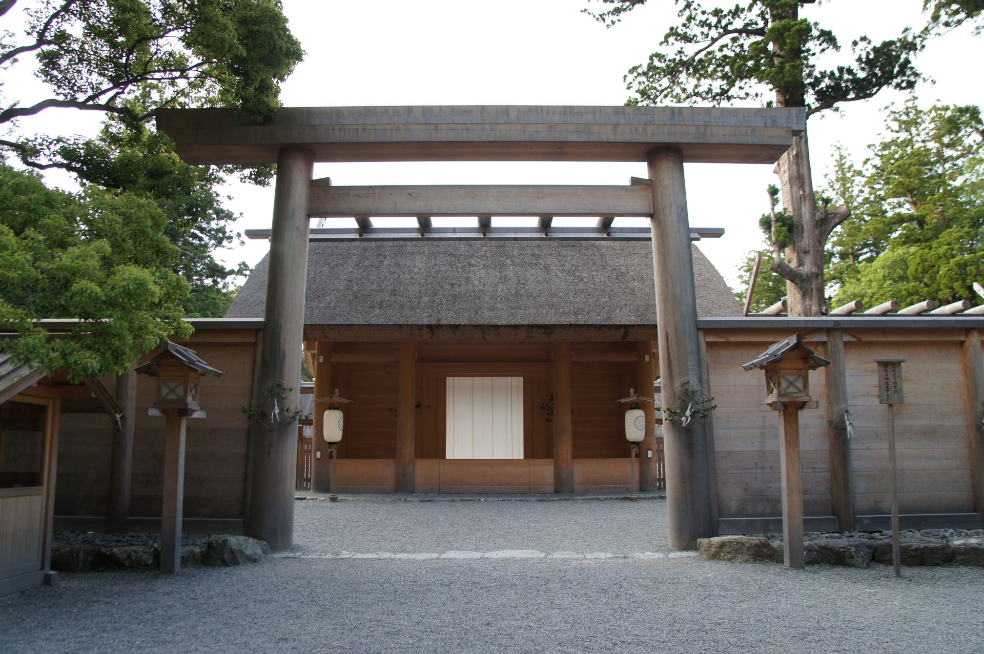夕方の正宮の門。白い幕の前に砂利が広がり、両脇に木が茂っている