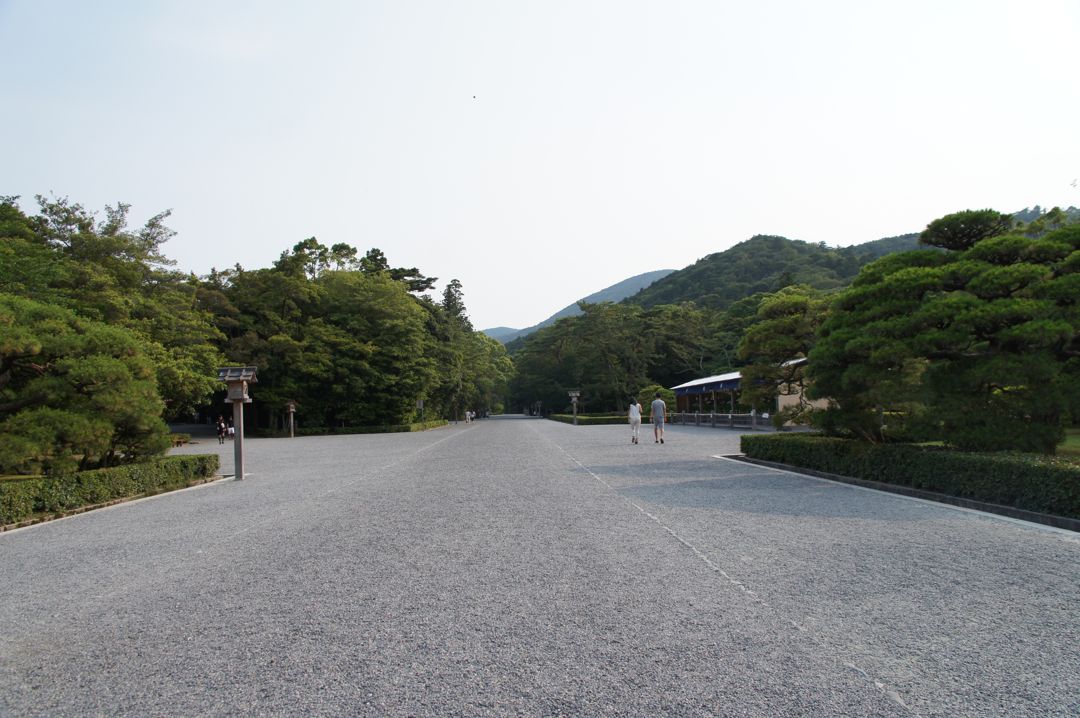 内宮の広い砂利の参道。道の両側に松と木々が並び、奥に人影が小さく見える