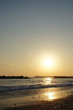 ひろの浜。夕日が水平線の少し上にあり、浜に光の帯が伸びている