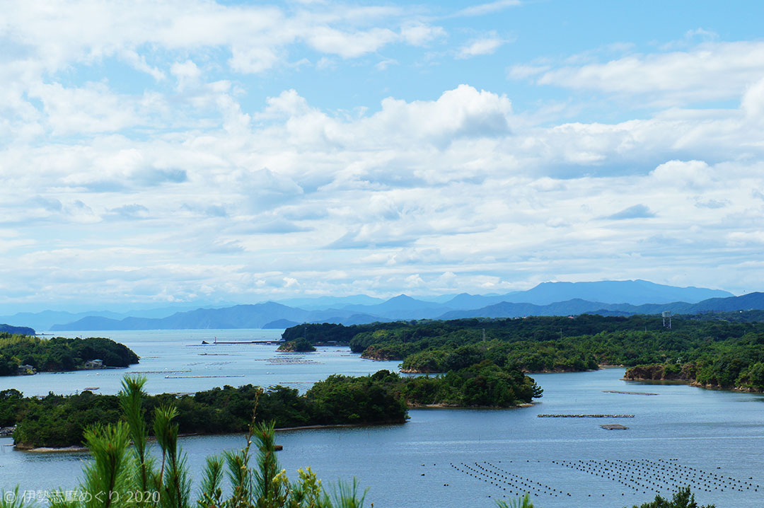 登茂山展望台。雲の多い空の下、島と筏の並ぶ湾