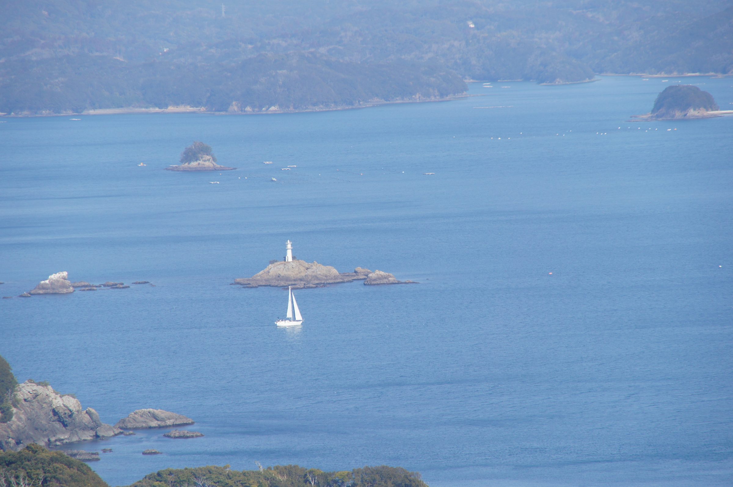 南海展望台。青い海と白い灯台、小さな帆