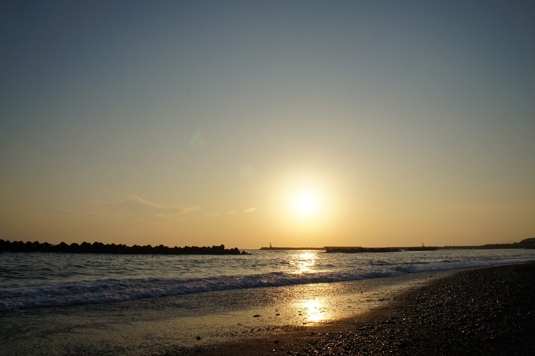 ひろの浜。夕日が水平線の少し上にあり、浜に光の帯が伸びている